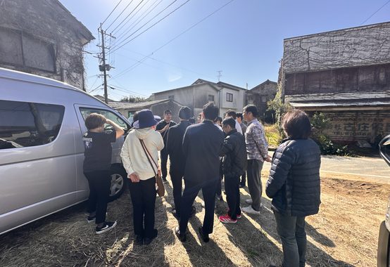 晴れた日の空き家の前に集まる現地見学会の参加者たち