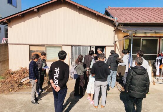 空き家の見学で建物の外観を確認する参加者たち