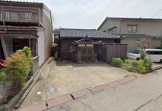 地方の住宅地に並ぶ古い戸建てと前面の道路