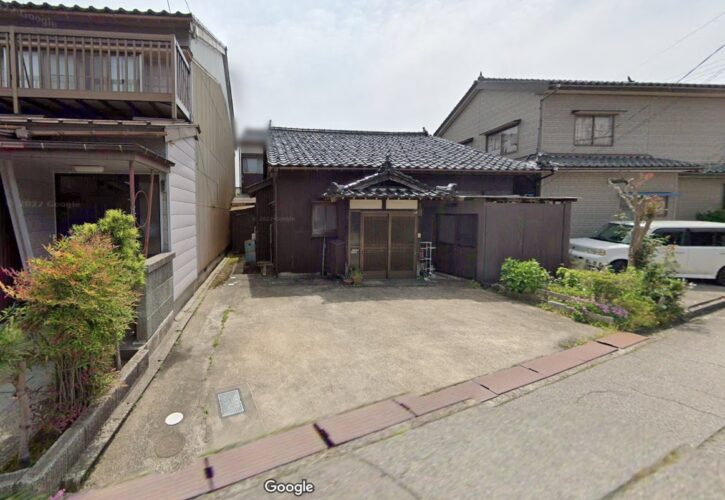 地方の住宅地に並ぶ古い戸建てと前面の道路